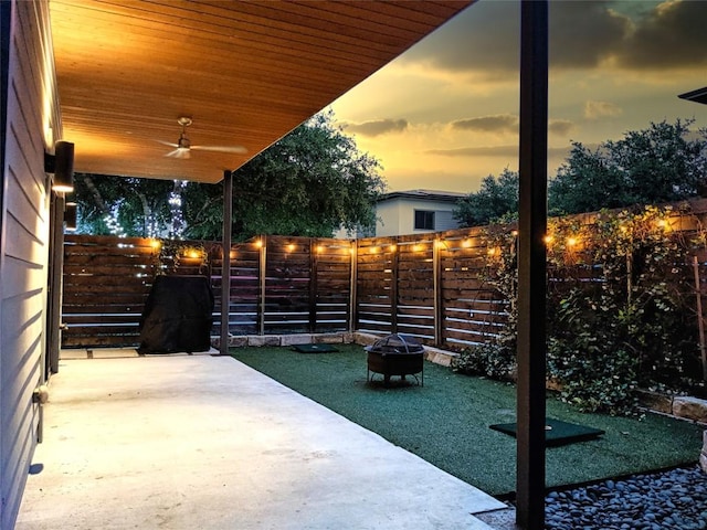 view of patio with a fire pit, ceiling fan, and a fenced backyard
