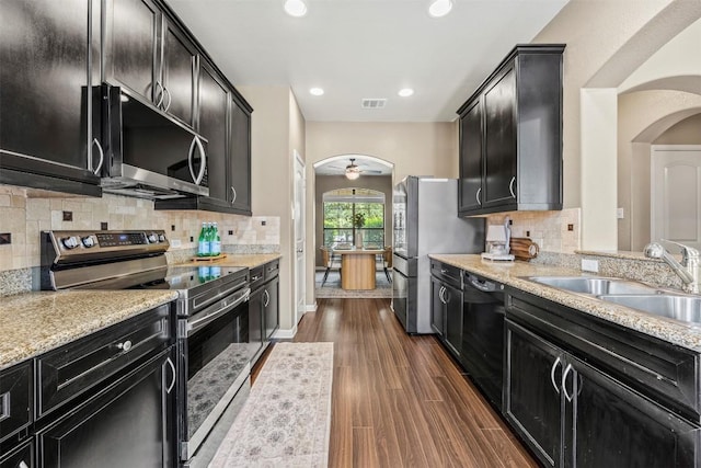 3306 Castleton Dr, Killeen, TX 76542 - kitchen with appliances with stainless steel finishes, arched walkways, dark cabinets, a ceiling fan, and recessed lighting