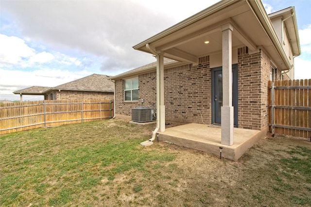 view of yard with central AC unit, a patio area, and a fenced backyard