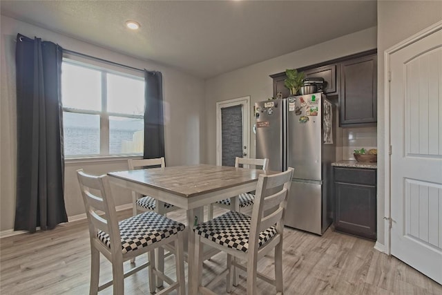 dining room with light wood-style flooring and baseboards