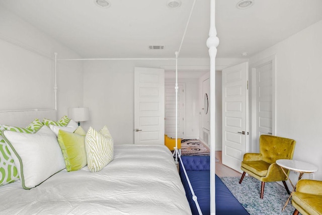 bedroom featuring visible vents and wood finished floors