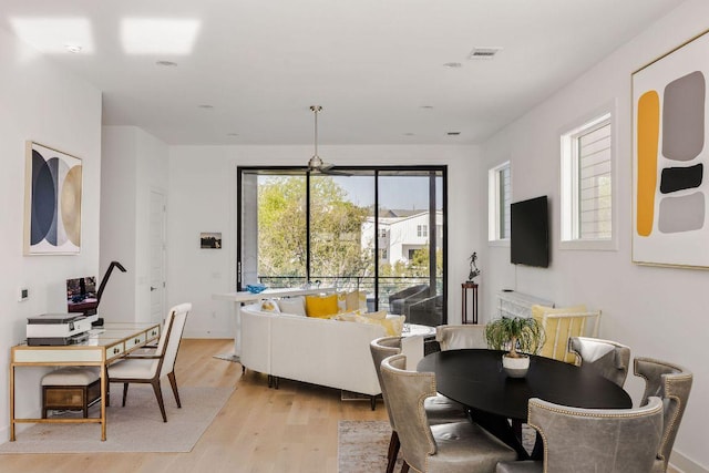 dining space with light wood-style floors and visible vents