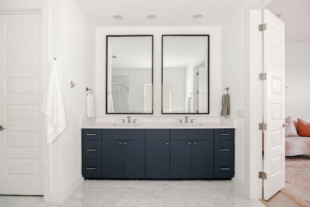 ensuite bathroom with marble finish floor, a sink, ensuite bath, and baseboards