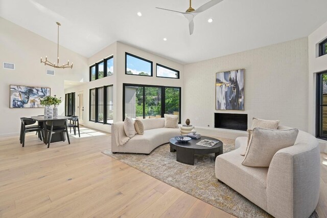 2001 Circle Hvn, Austin, TX 78741 - living room with a chandelier, light wood-style floors, ceiling fan, recessed lighting, and a towering ceiling