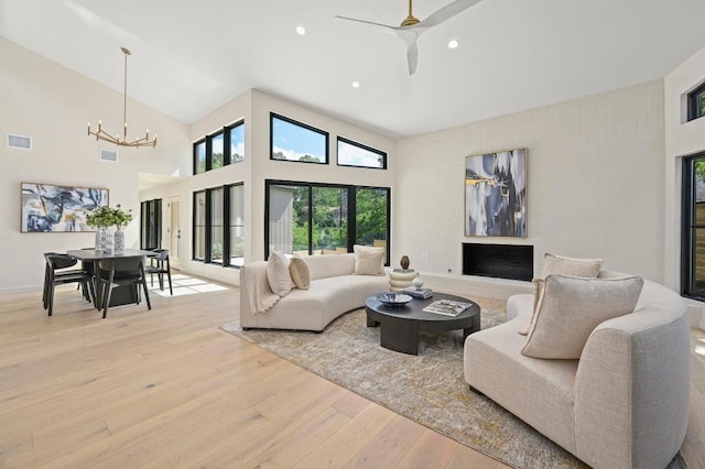 2001 Circle Hvn, Austin, TX 78741 - living room featuring a chandelier, light wood finished floors, a ceiling fan, recessed lighting, and a high ceiling