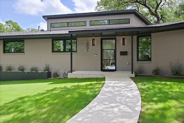 2001 Circle Hvn, Austin, TX 78741 - view of front facade featuring brick siding, a porch, and a front yard