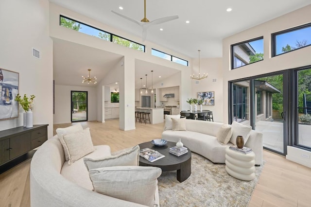 2001 Circle Hvn, Austin, TX 78741 - living area featuring a chandelier, light wood-style flooring, healthy amount of natural light, a towering ceiling, and recessed lighting