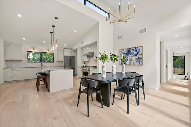 2001 Circle Hvn, Austin, TX 78741 - dining room featuring healthy amount of natural light, a chandelier, light wood-type flooring, baseboards, and recessed lighting