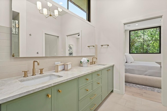 2001 Circle Hvn, Austin, TX 78741 - full bathroom with double vanity, decorative backsplash, a chandelier, tile patterned flooring, and a high ceiling
