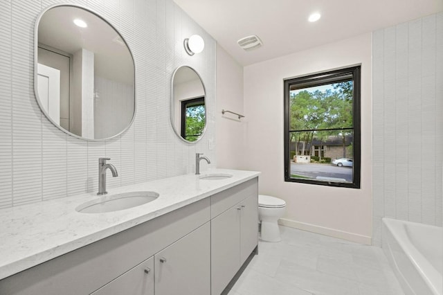 2001 Circle Hvn, Austin, TX 78741 - bathroom featuring double vanity, toilet, and baseboards