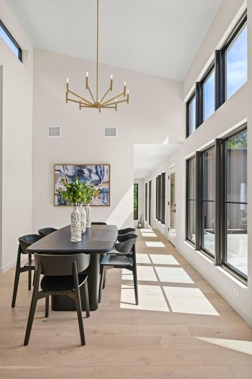 2001 Circle Hvn, Austin, TX 78741 - dining room with a towering ceiling, a chandelier, and light wood finished floors