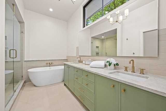 2001 Circle Hvn, Austin, TX 78741 - bathroom featuring double vanity, a stall shower, a soaking tub, tile walls, and a chandelier