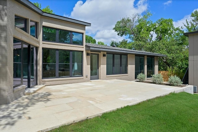2001 Circle Hvn, Austin, TX 78741 - back of property with a patio, brick siding, and a yard