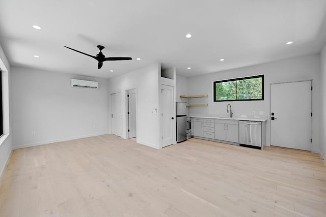 2001 Circle Hvn, Austin, TX 78741 - unfurnished living room featuring a wall unit AC, a sink, light wood-style floors, recessed lighting, and a ceiling fan