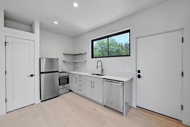 2001 Circle Hvn, Austin, TX 78741 - kitchen featuring appliances with stainless steel finishes, open shelves, light countertops, recessed lighting, and light wood finished floors
