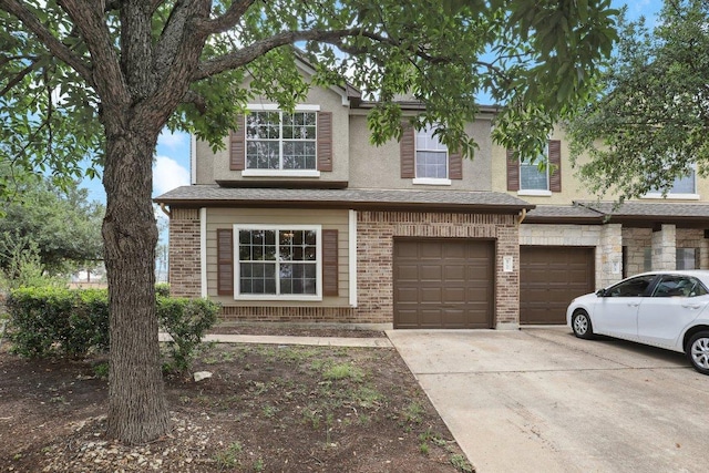 view of front of house featuring driveway, brick siding, and an attached garage