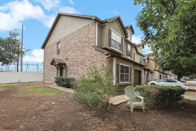 view of home's exterior featuring fence and brick siding