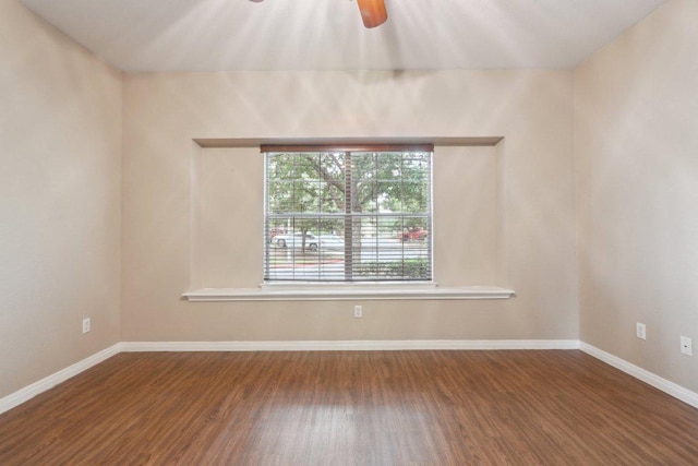 empty room with wood finished floors, a ceiling fan, and baseboards