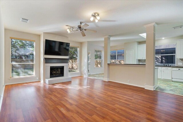 unfurnished living room featuring visible vents, ornate columns, ceiling fan, and light wood-style floors