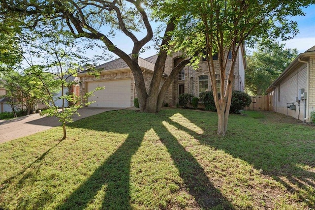 view of front facade featuring concrete driveway, a front yard, an attached garage, fence, and brick siding