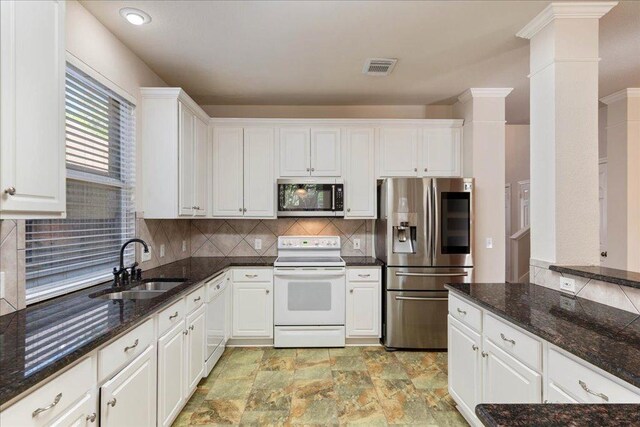 kitchen featuring appliances with stainless steel finishes, visible vents, white cabinets, and a sink