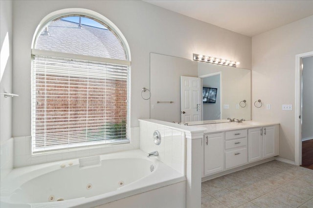 full bath featuring tile patterned flooring, a jetted tub, and vanity