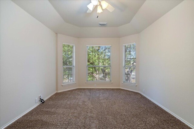 carpeted spare room featuring visible vents, ceiling fan, and baseboards