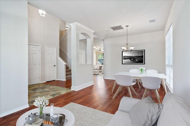 interior space featuring stairway, visible vents, wood finished floors, and a chandelier