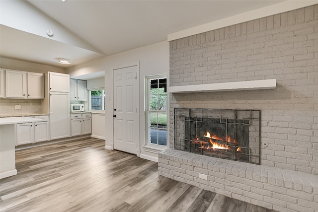 12600 Limerick Ave, Austin, TX 78727 - unfurnished living room with a fireplace, vaulted ceiling, and light wood-type flooring