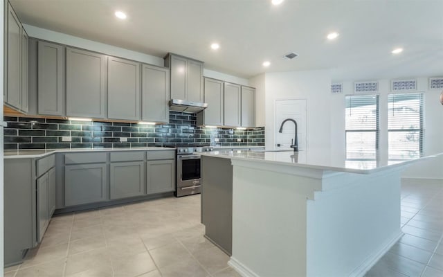 kitchen featuring gray cabinetry, tasteful backsplash, stainless steel electric range, and a sink