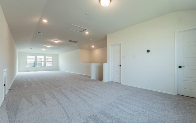 unfurnished room with attic access, visible vents, and light colored carpet