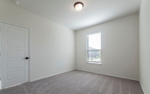 empty room featuring carpet floors and baseboards
