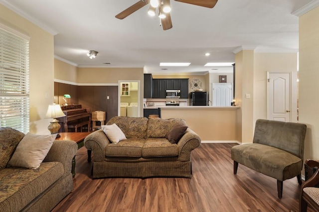 living room with crown molding, a ceiling fan, washing machine and clothes dryer, and wood finished floors