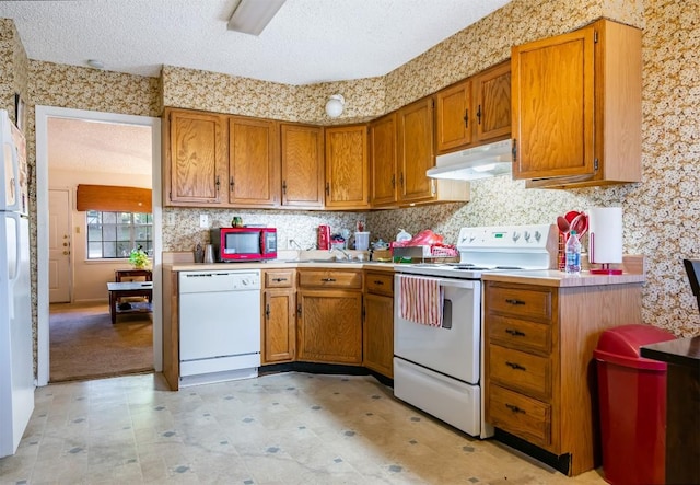 724 Woodcrest Cir, New Braunfels, TX 78130 - kitchen with white appliances, under cabinet range hood, brown cabinetry, and a textured ceiling