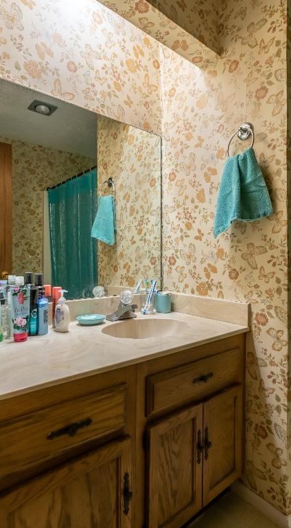 724 Woodcrest Cir, New Braunfels, TX 78130 - bathroom with wallpapered walls and vanity