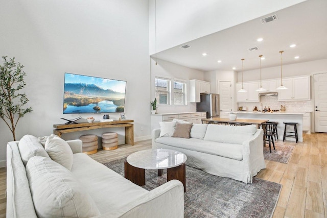 living area featuring visible vents, recessed lighting, and light wood-style flooring