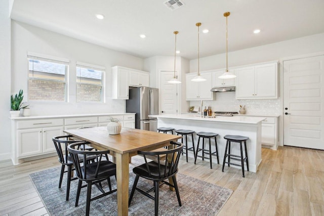 dining room featuring light wood finished floors, recessed lighting, and visible vents