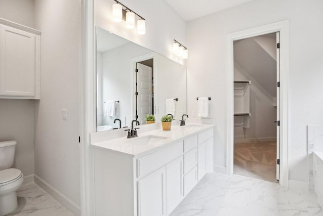 bathroom with toilet, baseboards, marble finish floor, and a sink