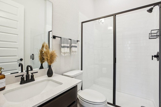 bathroom with vanity, toilet, and a stall shower