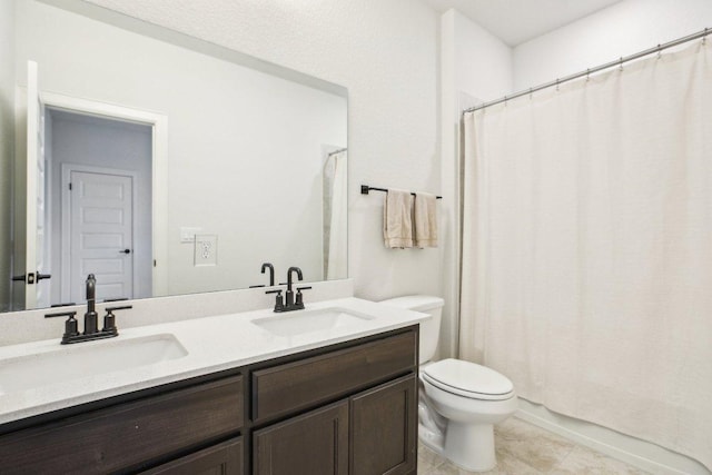 full bath featuring double vanity, toilet, tile patterned flooring, and a sink