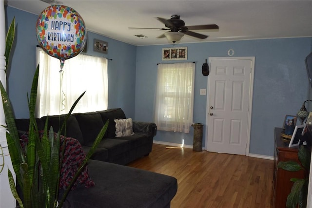 1200 NE 5th St, Smithville, TX 78957 - living room with a ceiling fan, visible vents, wood finished floors, and baseboards