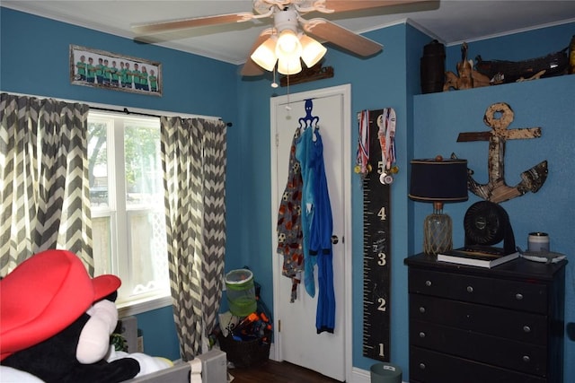 1200 NE 5th St, Smithville, TX 78957 - bedroom with ornamental molding, a closet, ceiling fan, and wood finished floors