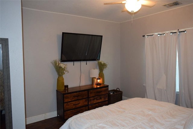 1200 NE 5th St, Smithville, TX 78957 - bedroom with ornamental molding, visible vents, wood finished floors, and baseboards