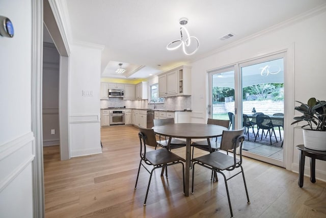 1702 Crested Butte Dr, Austin, TX 78746 - dining space featuring ornamental molding, light wood-style flooring, and a chandelier