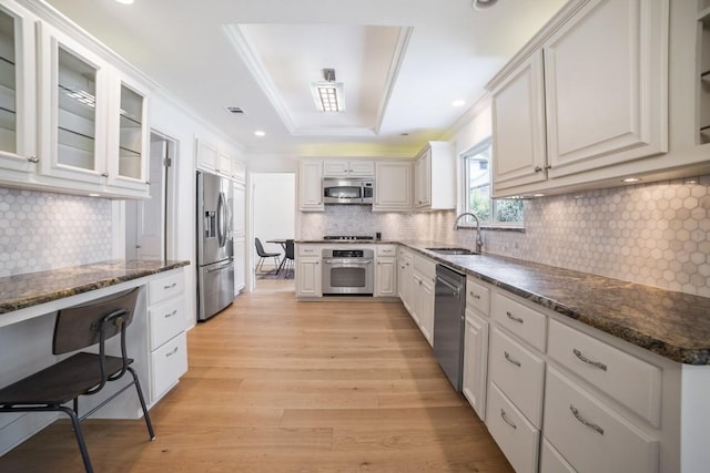 1702 Crested Butte Dr, Austin, TX 78746 - kitchen featuring appliances with stainless steel finishes, backsplash, light wood-style floors, crown molding, and white cabinets