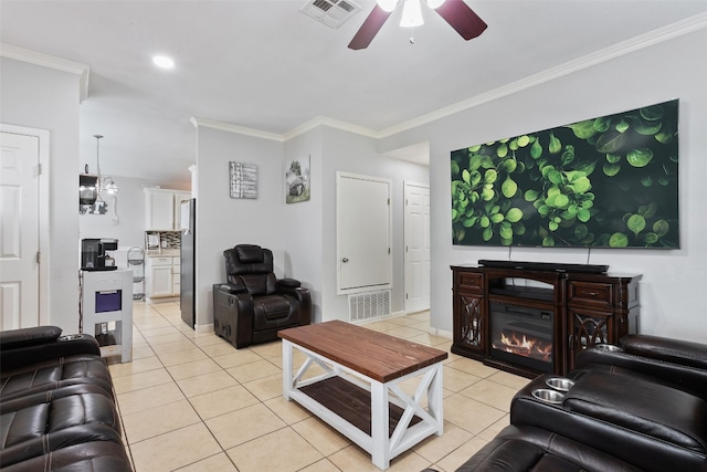 living room featuring ornamental molding, light tile patterned flooring, visible vents, and a ceiling fan