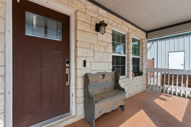doorway to property with covered porch and stone siding