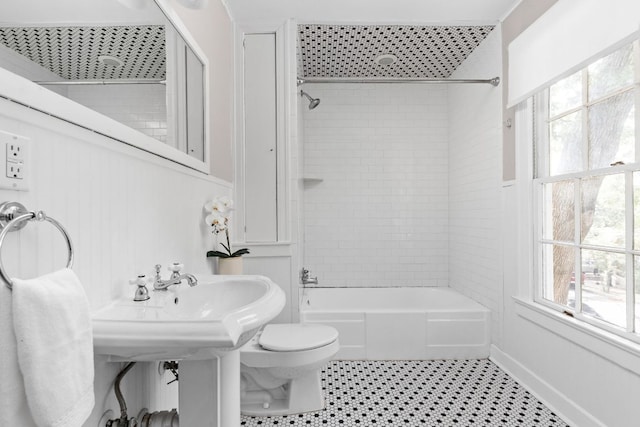bathroom with toilet, bathing tub / shower combination, and a wealth of natural light