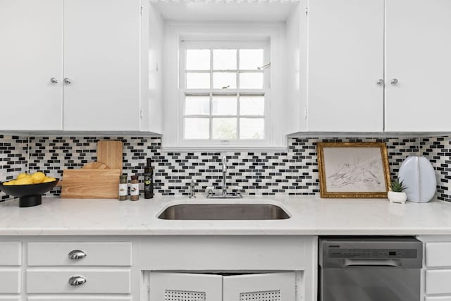 kitchen featuring a sink, backsplash, dishwasher, and white cabinetry