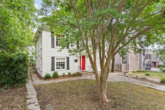 view of property hidden behind natural elements with fence